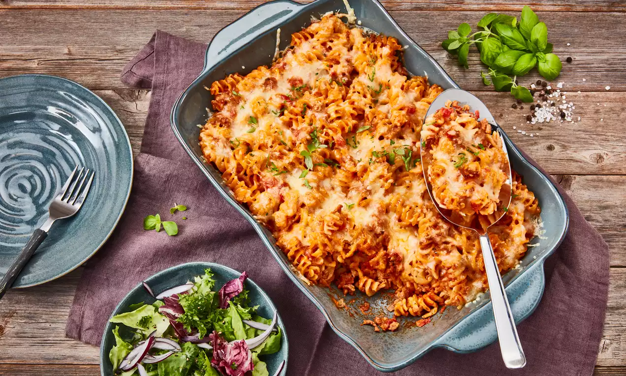 Nudelauflauf mit Hackfleisch: goldbraun überbackene Fusilli in würziger Tomatensauce mit geschmolzenem Käse und Petersilie in Auflaufform
